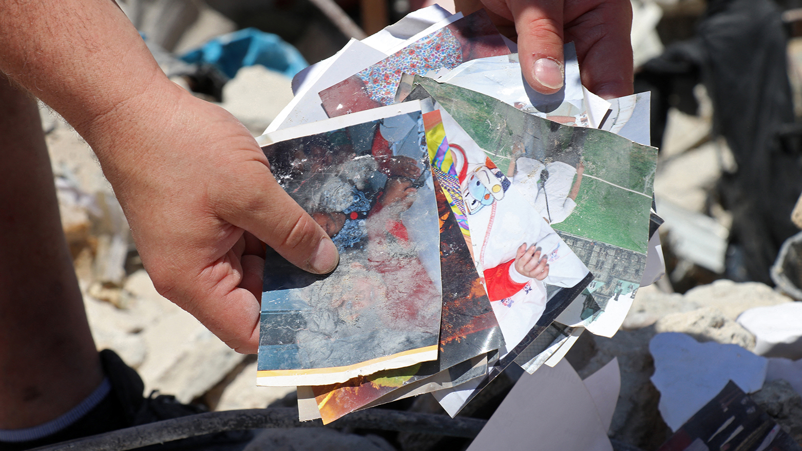 Resident Mohamad Ali Hijazi holds damaged family photo album amid rubble in Tyre, southern Lebanon, April 23 2026