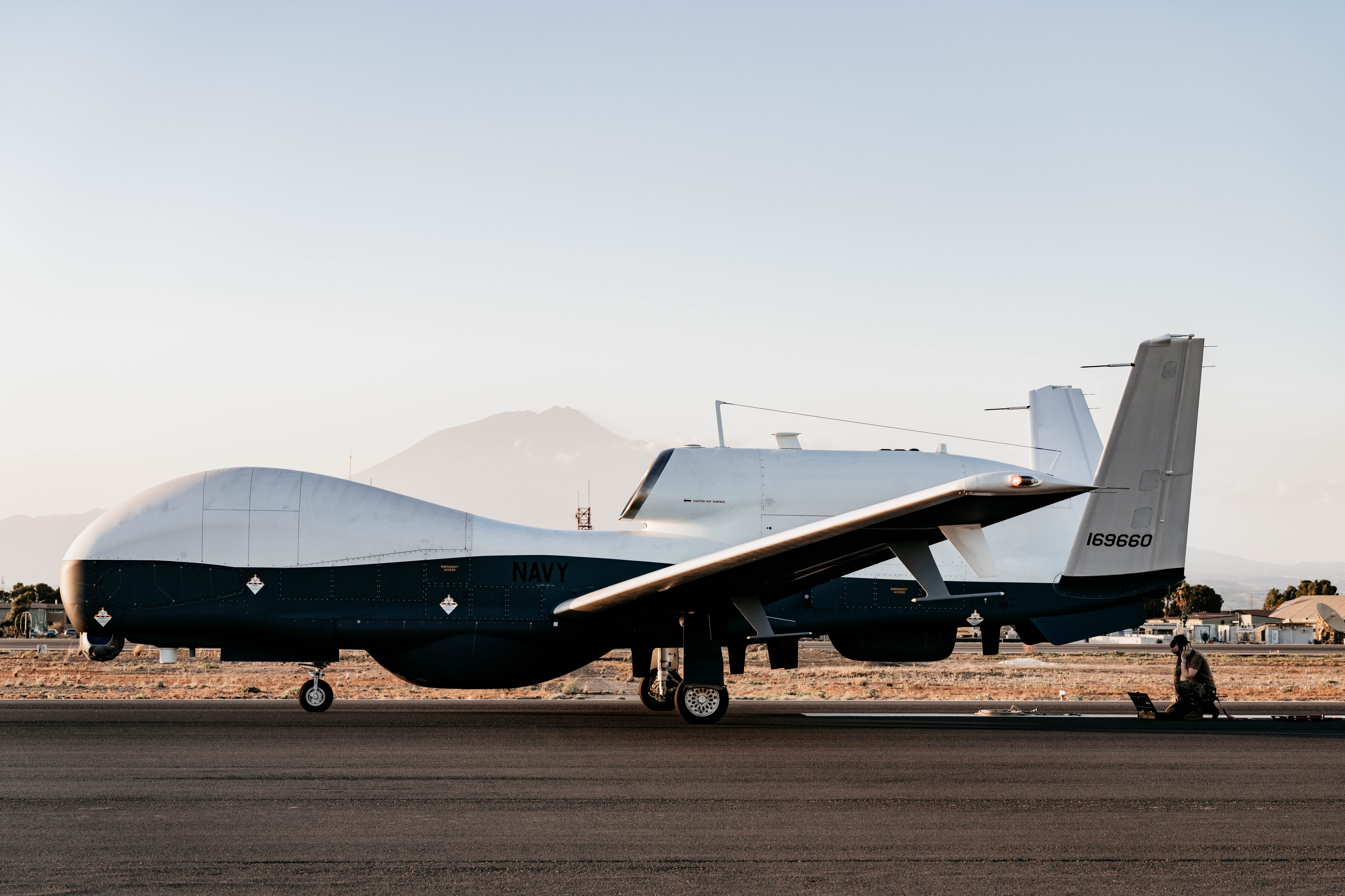 Aviation Electronics Technician conducts post-flight checks on an MQ-4C Triton at NAS Sigonella — the Navy's high-altitude maritime surveillance drone confirmed lost during Operation Epic Fury on April 9 2026