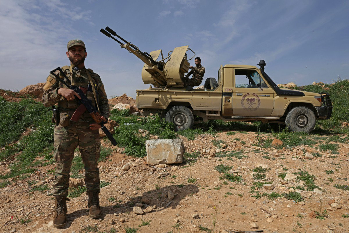 A Syrian army soldier stands guard next to an armoured vehicle on the Syrian-Lebanese border near Al Qusayr, April 2026, AFP